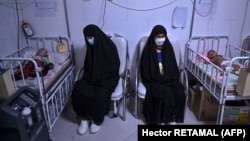 Women sit with their babies receiving treatment for malnutrition at a Doctors Without Borders nutrition center in the western Afghan city of Herat.