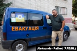 Illya Borsuk stands next to the vehicle he uses to evacuate people from hot spots in the Donbas.