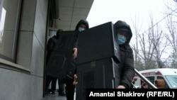 Kyrgyz security officers remove equipment from the Bishkek offices of the24.kg media outlet on January 15. 