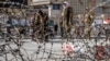 Taliban fighters stand guard at the explosion site near the Foreign Ministry in Kabul on March 27.