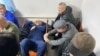 Bektur Asanov lies on a chair after one of the court hearings in the Kempir-Abad case. 