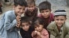 Afghan children pose for a photo at an Afghan refugee camp in Karachi on September 21.