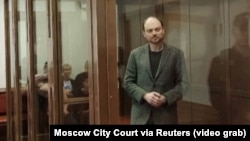 Russian opposition leader Vladimir Kara-Murza stands in the defendant's cage at the Moscow City Court on the final day of his trial, April 17, in which he was sentenced to 25 years in prison on charges of treason and spreading false information. 