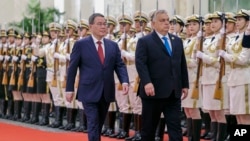 Hungarian Prime Minister Viktor Orban (right) and his Chinese counterpart, Li Qiang, review an honor guard during a welcome ceremony in Beijing on October 16, 2023.