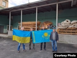 Марат Дәрменов (Украина туын ұстап сол жақта тұр) Киев облысында Ресей әскерінің оккупациясынан зардап шеккендерге көмек апарған еріктілермен бірге.