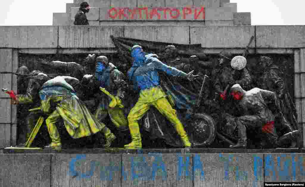 The oft-attacked panel of the Sofia memorial painted in the colors of the Ukrainian flag on February 27, 2022. Graffiti at the top of the image reads: &ldquo;Occupiers.&rdquo;