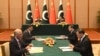 Pakistan's interim prime minister, Anwaar-ul Haq Kakar (back left), and his Chinese counterpart, Li Qiang (back right), look on as officials of both states signing agreements as part of the China-Pakistan Economic Corridor in Beijing on October 18. 