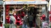 Afghan men walk past a gift shop along Flower Street in the Shar-e Naw area of Kabul on February 14. 