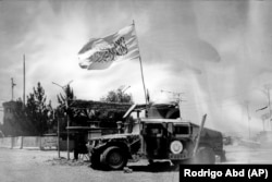 A Taliban flag waves from a U.S. military vehicle that was used during the years of U.S. military intervention, on the outskirts of Kabul on June 21.