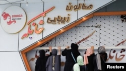 Afghan beauticians close their beauty salon in Kabul on July 24.