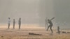 Youths play cricket amid smoggy conditions in Lahore on November 14. 