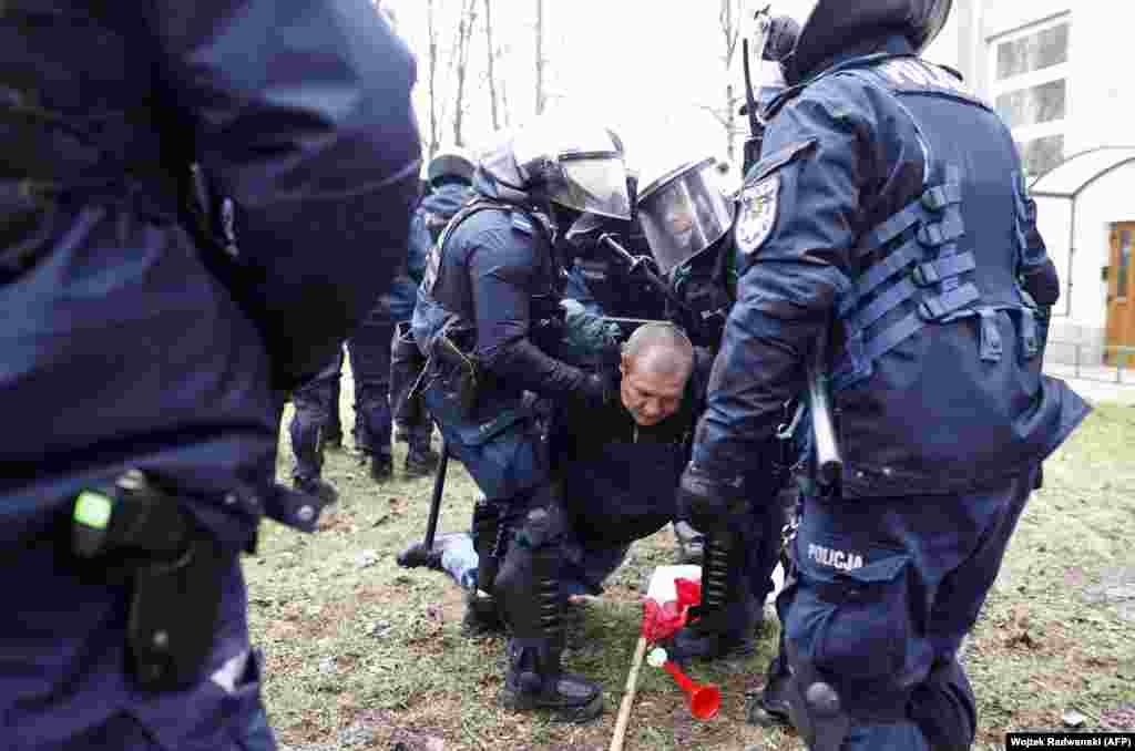 A man is restrained by police during the protests outside the Polish parliament.&nbsp; Twenty-three people were detained during the unrest, in which police deployed pepper spray, batons, and stun grenades according to a Reuters witness. Protesters were seen throwing objects, including cobblestones, at police.&nbsp;