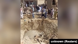 People gather near rubble in the aftermath of Pakistan's military strike on an Iranian village in Sistan-Baluchistan Province on January 18.