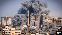 Smoke plumes billow during Israeli air strikes in Gaza City on October 12.