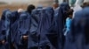 Displaced Afghan women wait in line to receive cash aid in Kabul. (file photo)