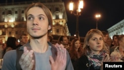 Belarusians applaud as they participate in an antigovernment protest in Minsk on September 21.