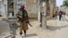 A Taliban fighter stands guard at the site of an explosion in Kabul last month.