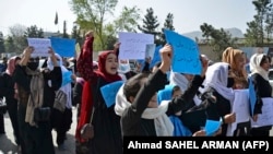 Afghan women and girls take part in a protest in front of the Ministry of Education in Kabul on March 26, 2022, demanding that high schools be reopened for girls.