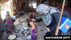 A health worker administers polio vaccine drops to a child during a vaccination campaign in Karachi, Pakistan, on November 28, 2022. 