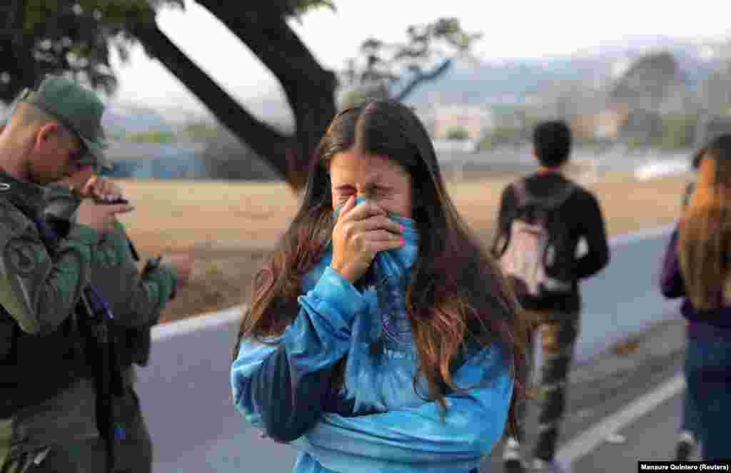 A woman reacts to tear gas near the Generalisimo Francisco de Miranda Air Base&nbsp;in eastern Caracas.&nbsp;