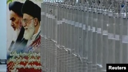 A poster of Supreme Leader Ayatollah Ali Khamenei and the late Ayatollah Ruhollah Khomeini is seen next to a bank of centrifuges in what was described by Iranian state television as a facility in Natanz in 2012.