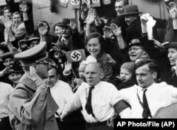 German Chancellor Adolf Hitler is welcomed after crossing the Czechoslovak border into Sudetenland on October 3, 1938.