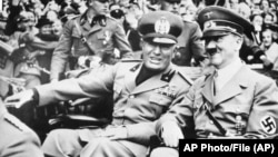 Italian dictator Benito Mussolini (left) and Nazi leader Adolf Hitler arrive at the four-power conference in Munich, Germany, on September 28, 1938. 