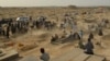 Mourners gather next to graves of victims of the October 8 suicide bomb attack on worshippers at a Shi'ite mosque in Kunduz, in which at least 55 people died. The attack was claimed by the Islamic State-Khorasan.