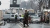 A Taliban security officer stands guard on a blocked road after a blast near Afghanistan's Foreign Ministry in Kabul on January 11. 