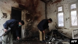 Pakistani policemen inspect the Peshawar police station following the bomb attack on February 24.