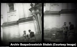 Two men chatting at the entrance of a church near Prague Castle.