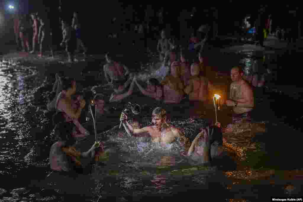 Orthodox believers made it a festive celebration as they bathed in the icy waters near Vilnius, Lithuania.