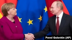 German Chancellor Angela Merkel and Russian President Vladimir Putin shake hands after their joint news conference following talks in the Kremlin in January 2020.