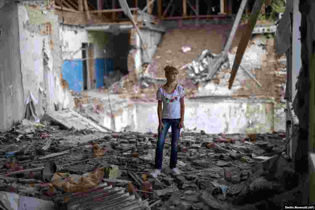 Sofia Klyshnia, 12, stands amid the rubble of her former classroom, in the same place where her desk once stood. &quot;It&#39;s scary to stand in the destroyed part of the class where I once studied,&quot; she said.