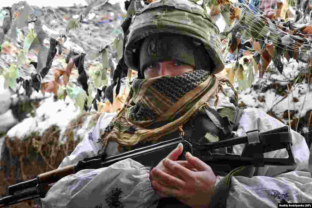 A Ukrainian soldier keeps watch in a trench on January 29 at the front line with the separatists in the village of Verkhnotoretske in the Donetsk region.