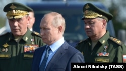 Russian General Valery Gerasimov (left), President Vladimir Putin (center), and ex-Defense Minister Sergei Shoigu (file photo) 