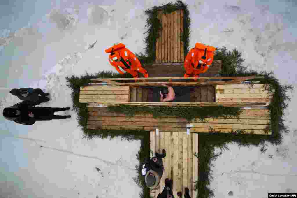 Thousands of Orthodox followers plunged into outdoor rivers, ponds, or other pools, such as these people under the watchful gaze of rescue workers in Kronstadt, outside St. Petersburg, Russia, on January 18. &nbsp;