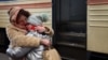 A mother holds her crying daughter after their arrival by train from Kharkiv at the main train station in the western city of Lviv on March 4.