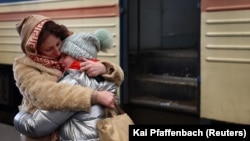 A mother holds her crying daughter after their arrival by train from Kharkiv at the main train station in the western city of Lviv on March 4.