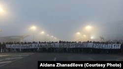 Республика алаңында "Қарапайым халықпыз. Біз — террорист емеспіз!" деген жазу ұстап тұрған адамдар. Оқиға куәларының айтуынша, біраз уақыттан кейін алаңның үкімет күштері тұрған бетінен осы адамдарға оқ жауған. Алматы, 6 қаңтар 2022 жыл.