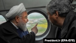 Iranian President Hassan Rohani (left) inspects the flood-affected villages in Golestan Province from a helicopter on March 27.