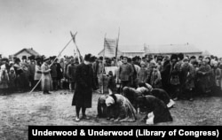 Russian famine victims kneel before a U.S. relief official in 1922 in Samara.