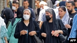 Women wearing head scarves walk in the streets of Tehran on July 12. Since the country's 1979 Islamic revolution, Iranian law requires all women to wear a hijab that covers the head and neck while concealing the hair. But many have pushed the boundaries over the past two decades.