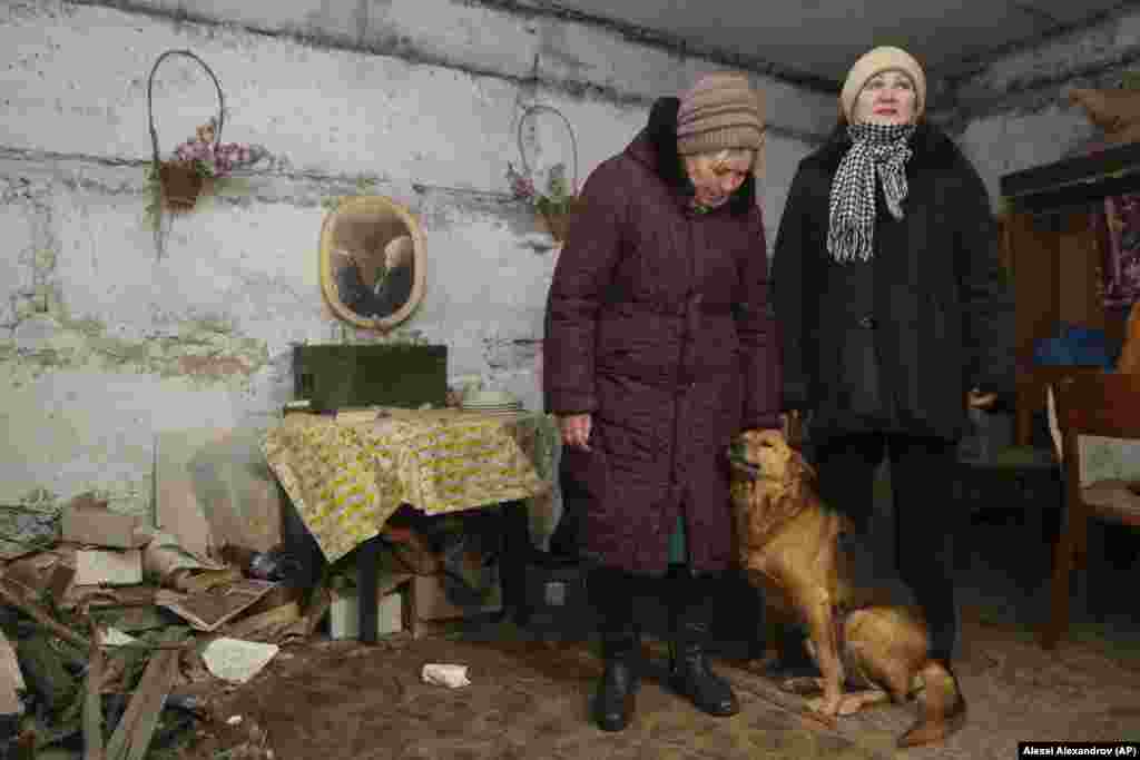 Lilia (left) and Tetyana, both residents of a village on the outskirts of Donetsk, speak to a journalist in a basement used as a bomb shelter on January 30. They live in an area controlled by the separatists, not far from the front line with government forces. Lilia and five other people live in a five-story apartment building without heat or water. Many houses in the region were abandoned because of heavy damage incurred during the military conflict in 2014-15.&nbsp;