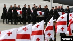 An honor guard carries the coffins of Georgian soldiers killed in Afghanistan at the airport in Tbilisi on May 16.