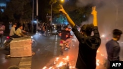 A photo obtained by AFP shows a demonstrator making the victory sign during a protest for Mahsa Amini in Tehran on September 19.