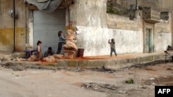 Children hide behind sandbags on the street in the central Syrian town of Rastan, near Homs.