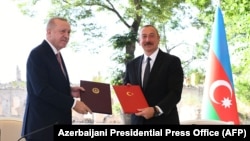 Turkish President Recep Tayyip Erdogan (left) and Azerbaijani President Ilham Aliyev attend a signing ceremony in Susa/Shushi in Nagorno-Karabakh on June 15.