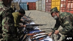 Afghan Army officers inspect weapons collected from private security companies in Kabul earlier this month.