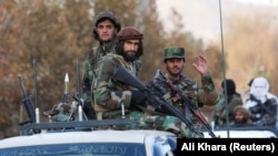 Taliban fighters sit on a vehicle during a military parade in Kabul. 